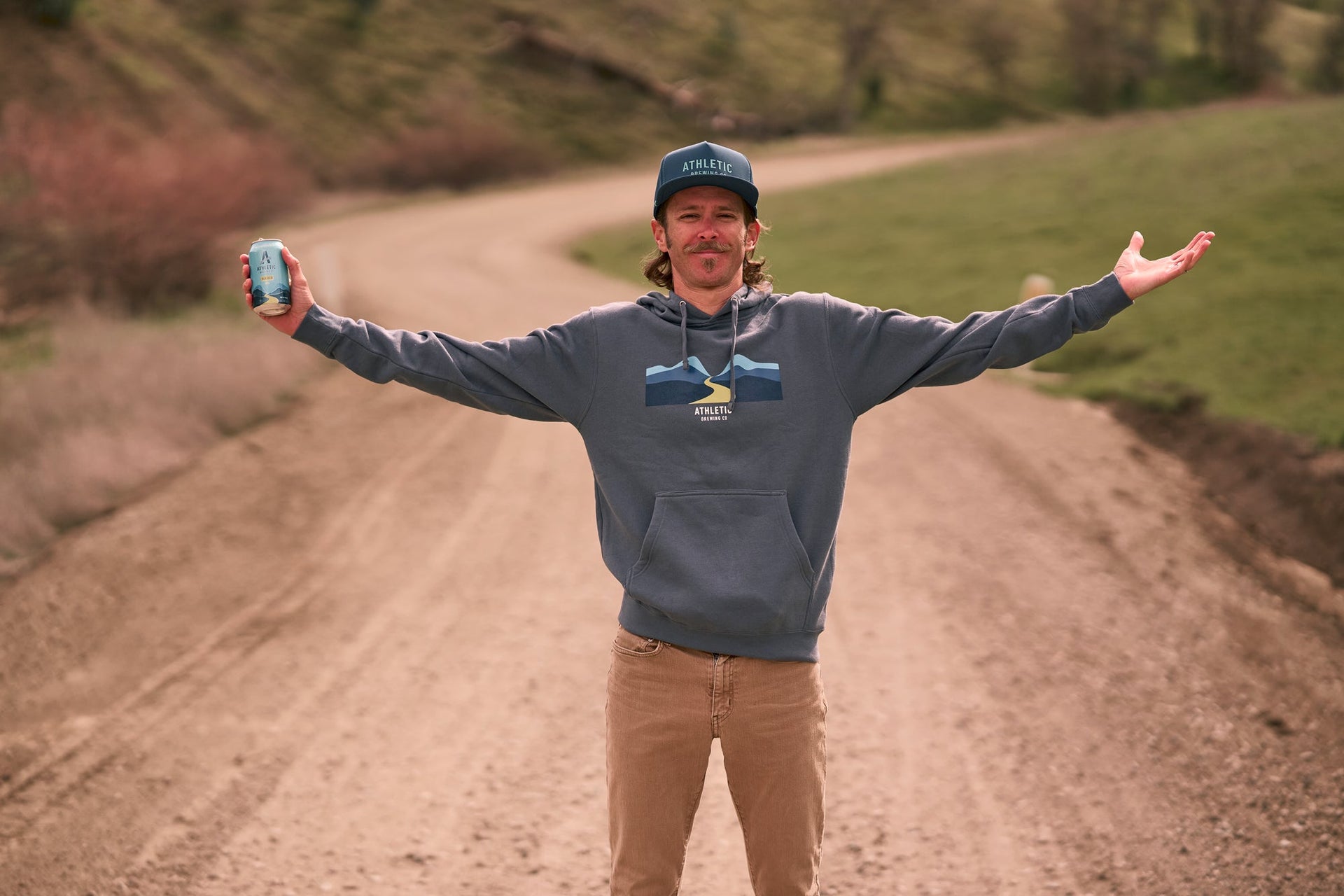 Pete Stetina on a dirt road holding a can of NA beer