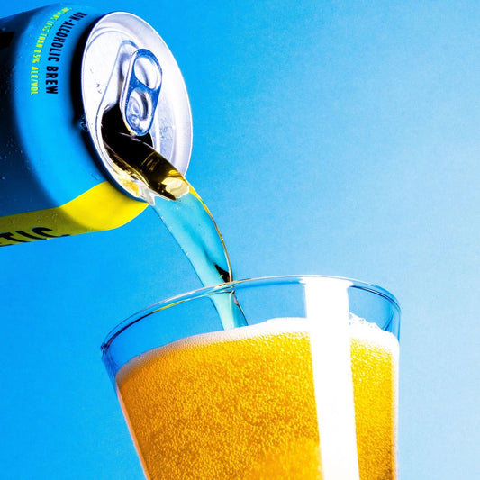 pouring can of Run Wild into glass in front of blue background