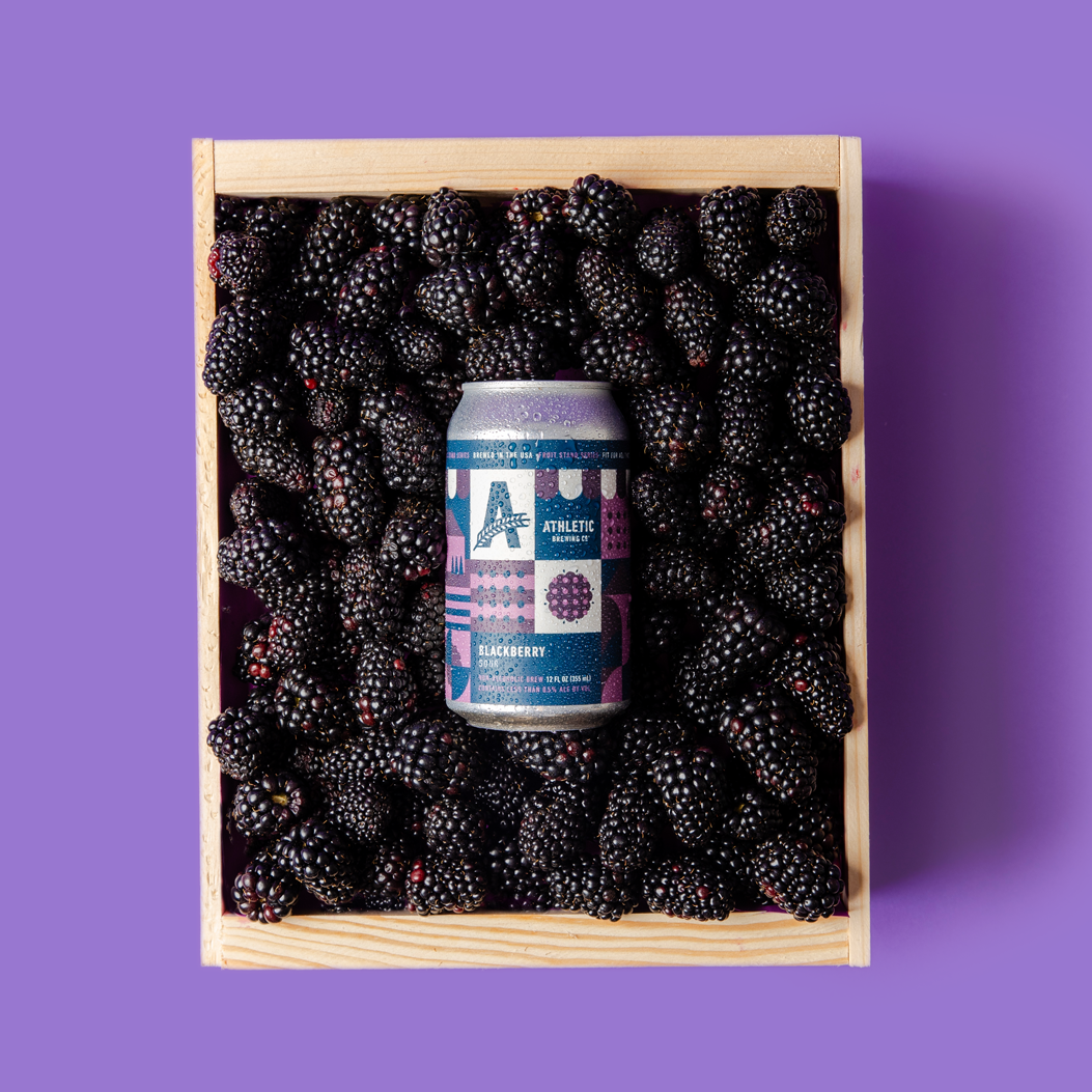 Blackberry Sour can nestled in a crate of blackberries.