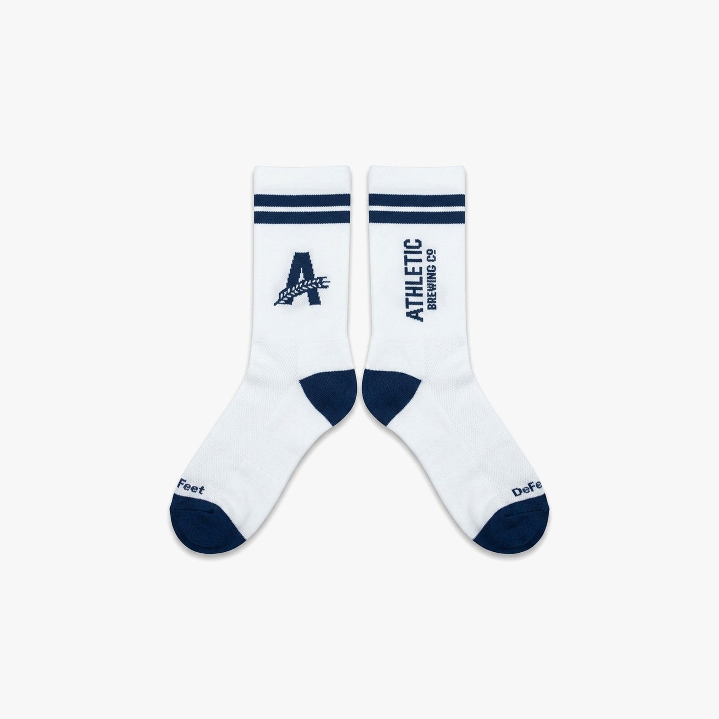 Flat lay of white Athletic Brewing crew performance socks with navy toe and heel accents, striped cuffs, “A” logo branding on one sock, and vertical Athletic Brewing Co. text logo on the other.