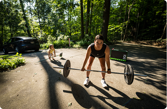 mom and daughter lifting weights in driveway
