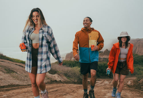 group of friends hiking with NA beers