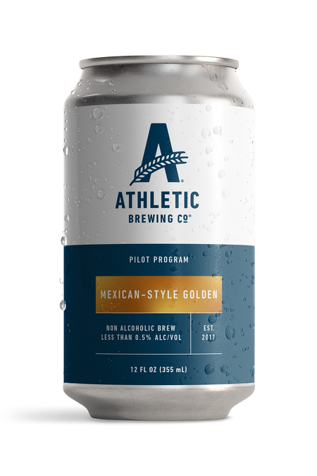 12 fl oz can of Athletic Brewing Pilot Program Mexican-Style Golden non-alcoholic brew with a clean white and navy label accented by a gold nameplate. The can is covered in condensation droplets and features the Athletic Brewing logo, “Pilot Program” branding, and product details including “Less Than 0.5% Alc/Vol.” The can is photographed against a black background, highlighting the limited-release beer packaging.