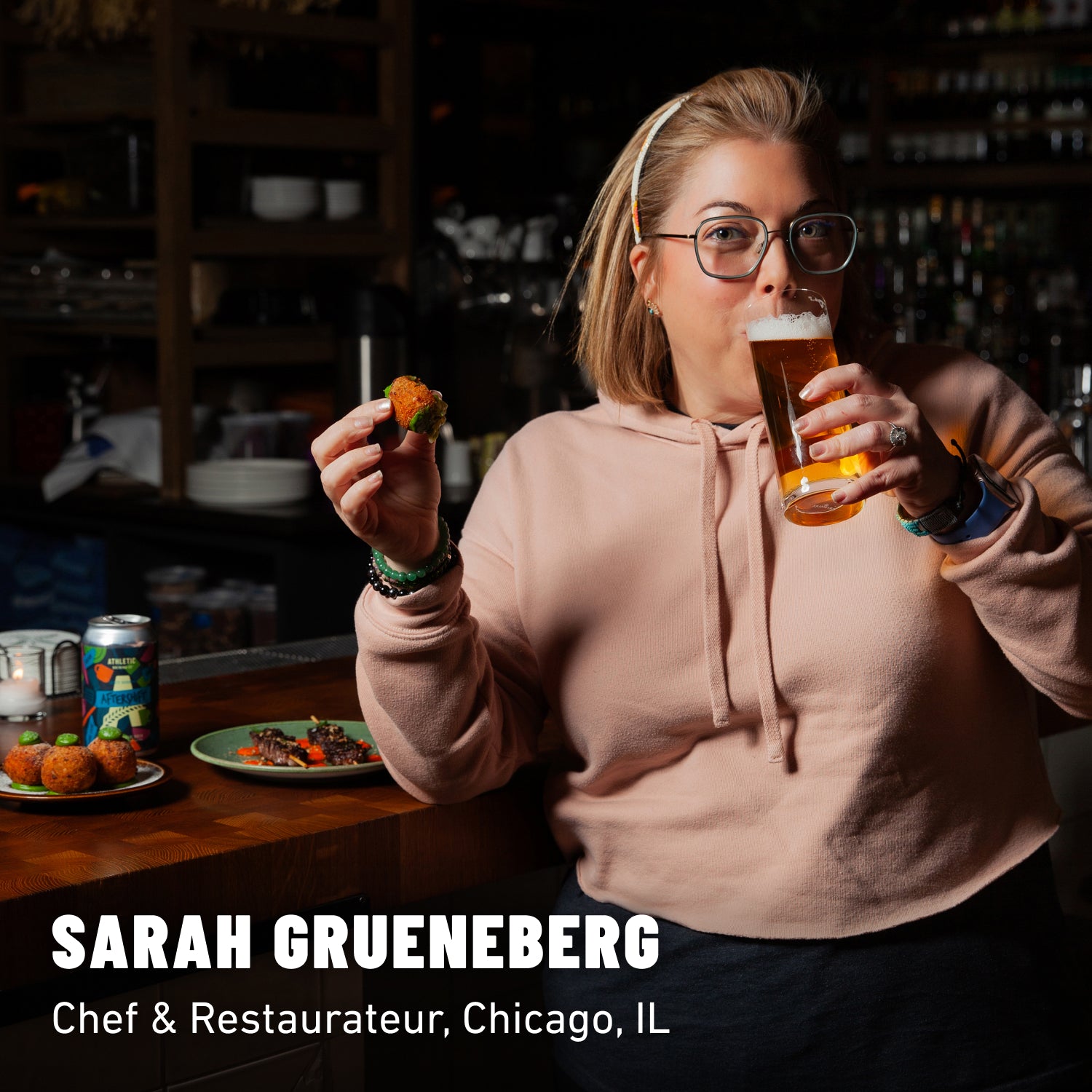 Sarah Grueneberg sipping a glass of non-alcoholic beer at a bar top