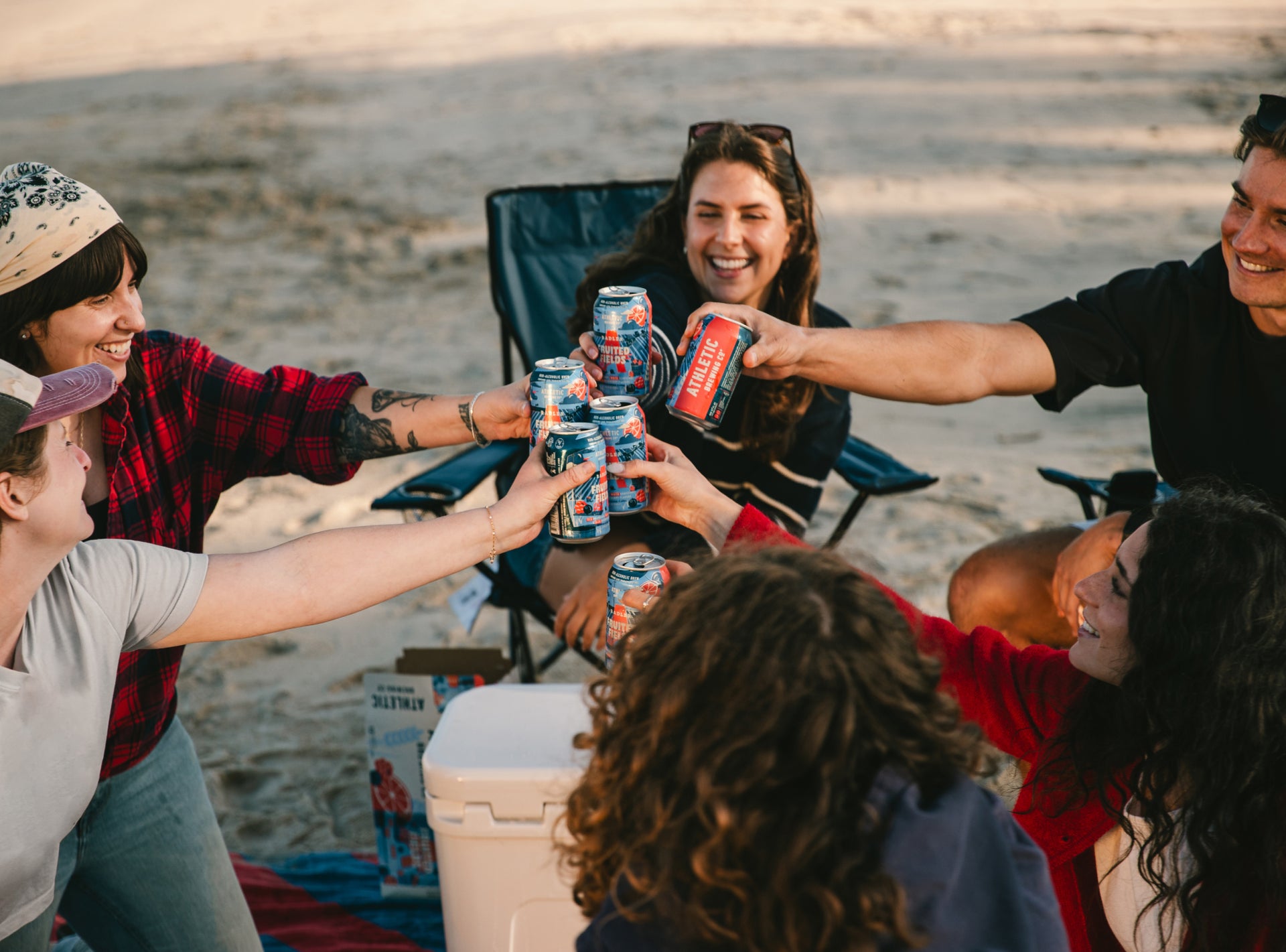 group of people on a beach drinking fruited field NA 4th of July Beer