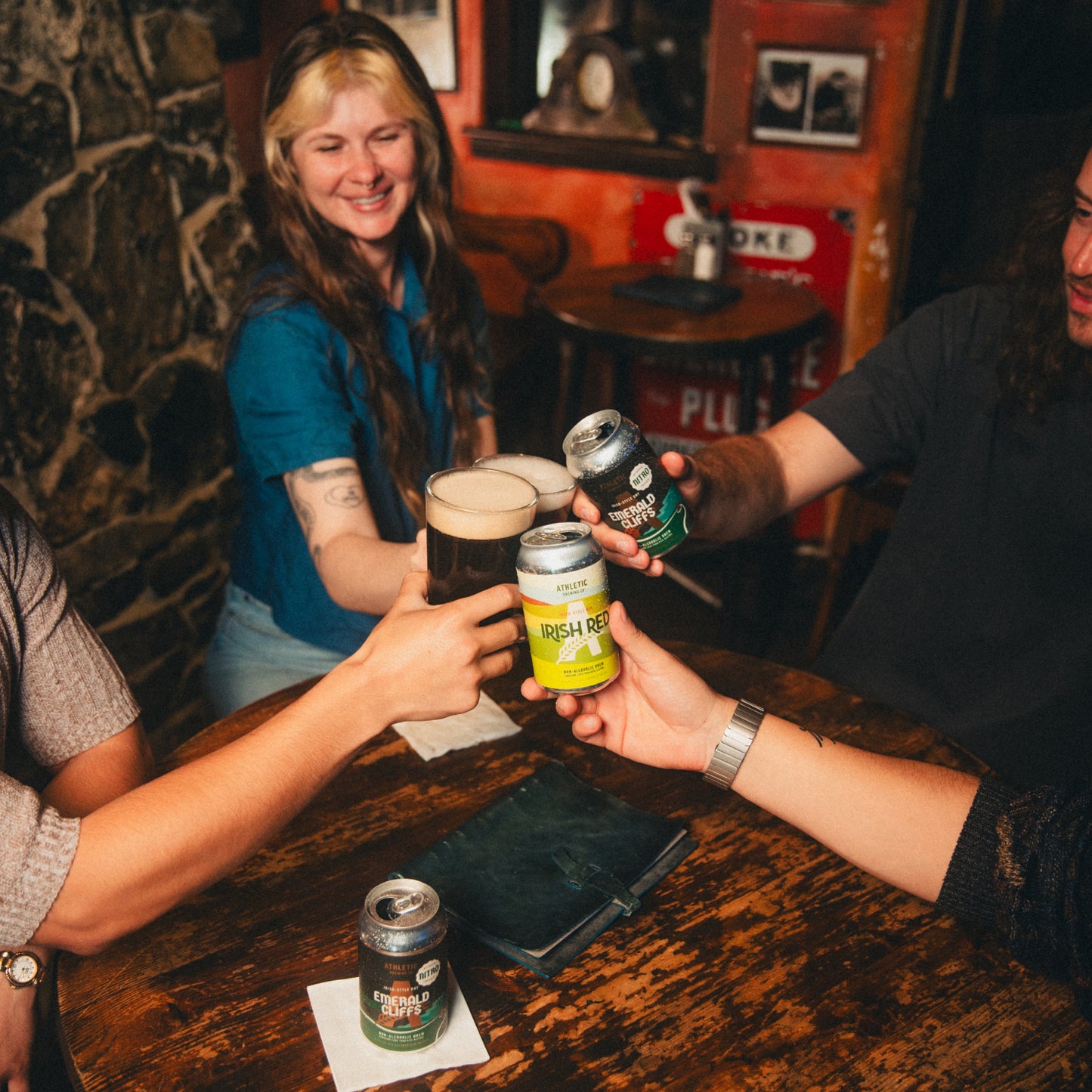 Friends toasting with Irish Red and Emerald Cliffs in a pub.