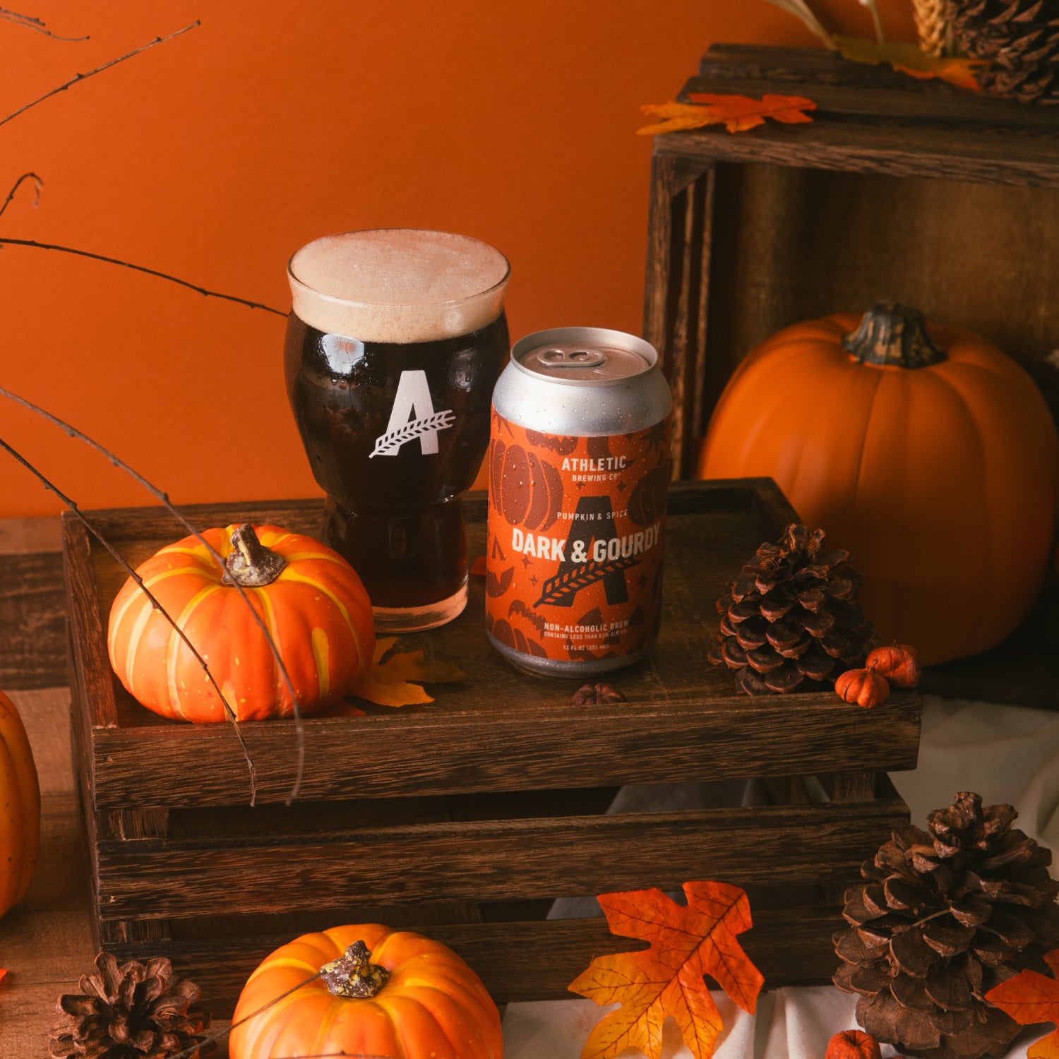 a can and a glass of dark&gourdy surrended by pumpukins and maple leaves