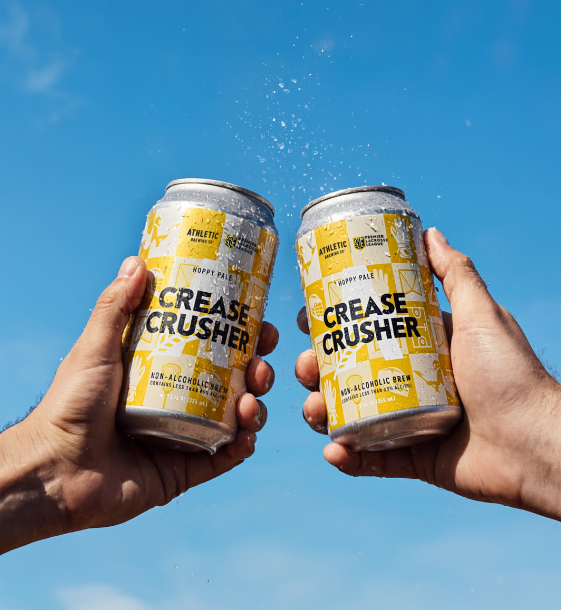 two cans of Crease Crusher NA beer cheersing