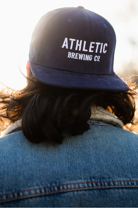 Wearing Athletic Brewing har in a field