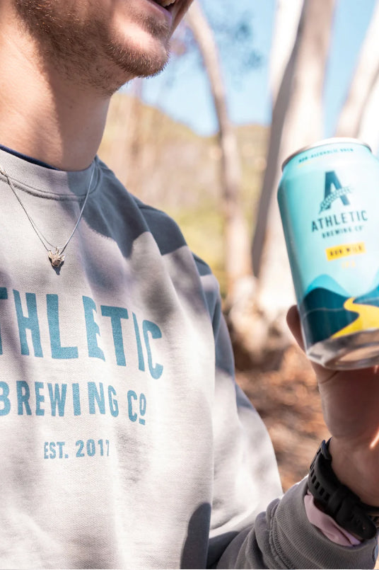 Drinking from a can while wearing an Athletic Brewing sweater