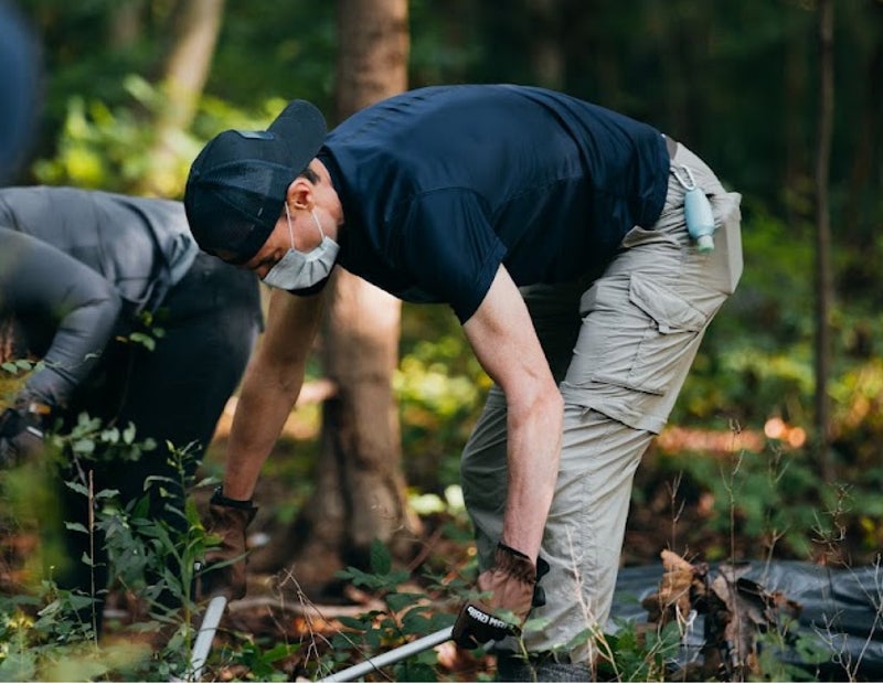 person cleaning trail