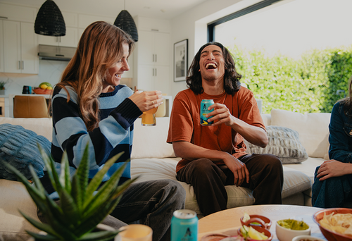 Friends on couch enjoying NA beer