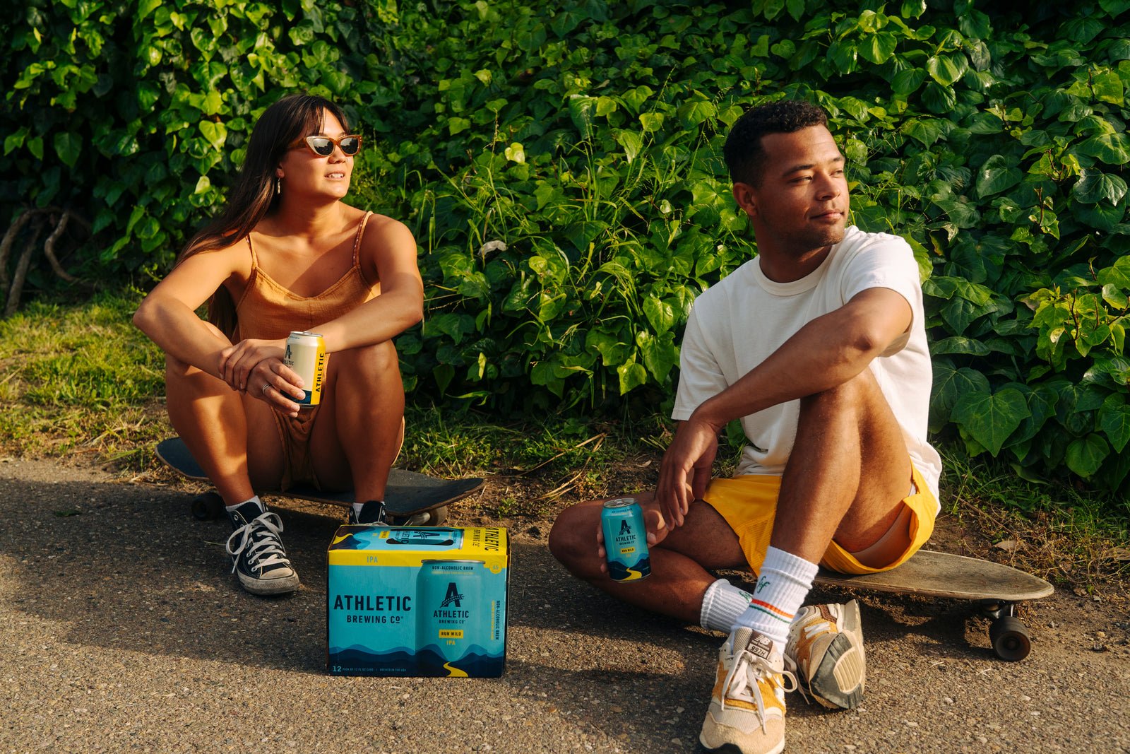 Two skateboarders sitting next to a pack of Run Wild