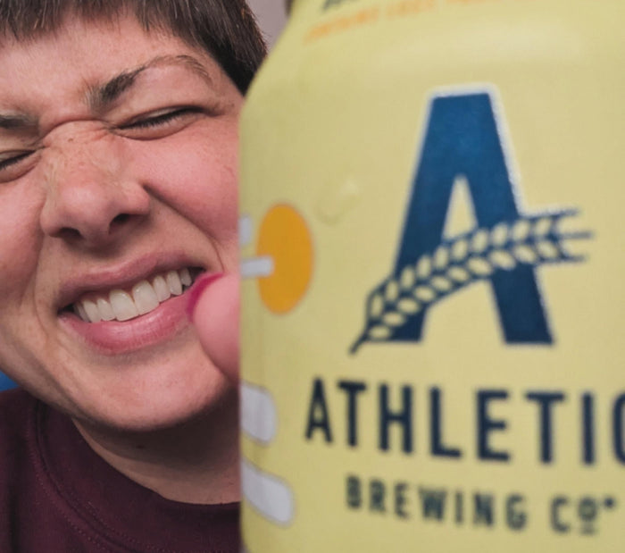 person smiling with a can of Athletic