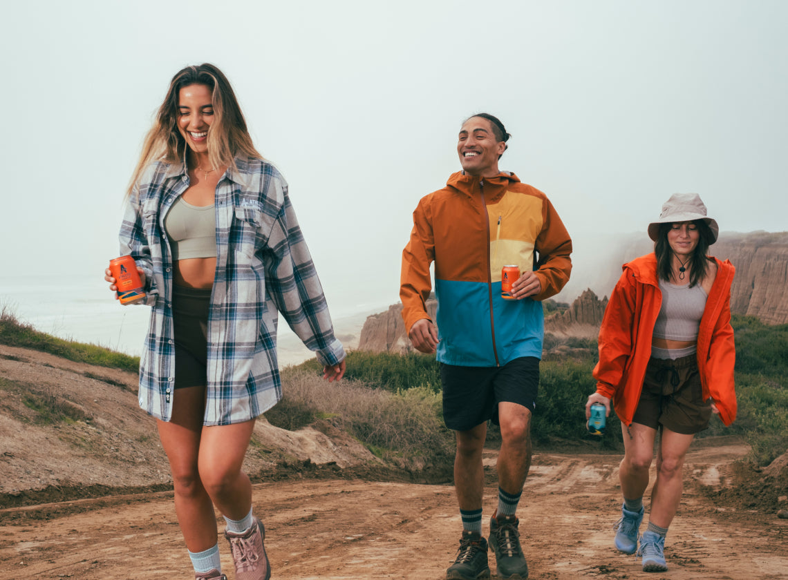 friends on a hike with Athletic brews in hand