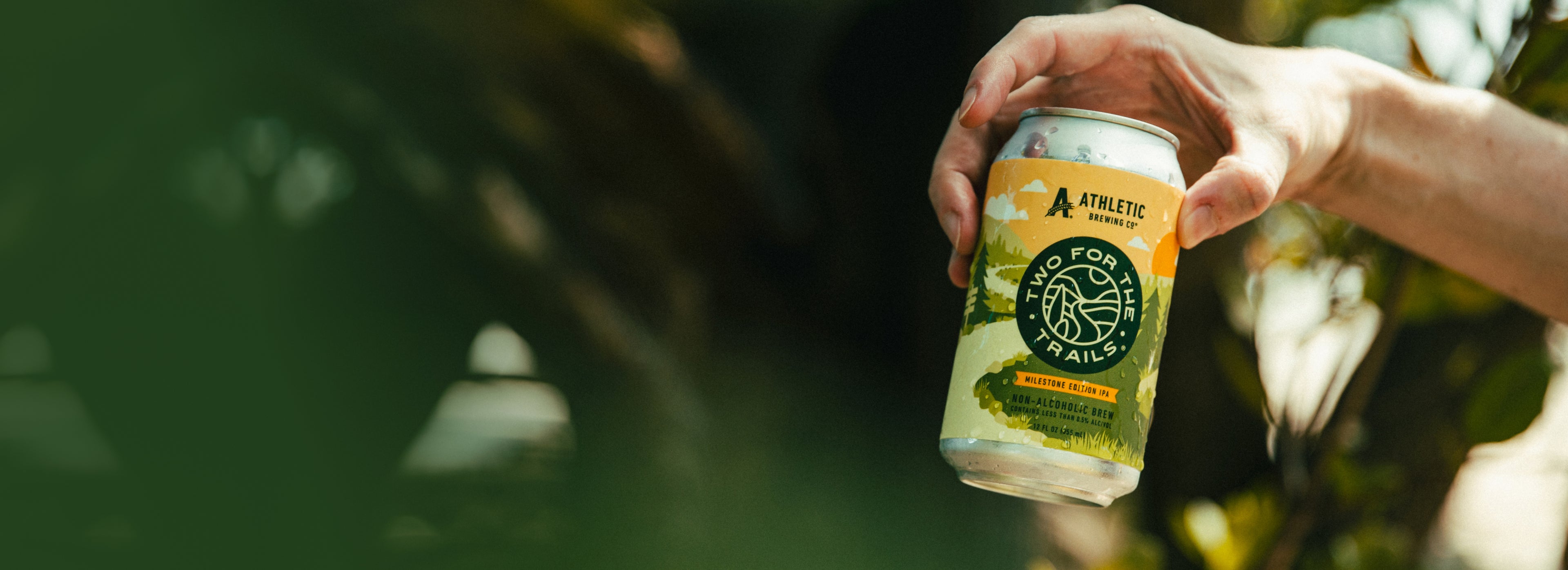 holding a can of the Two For The Trails brew in nature
