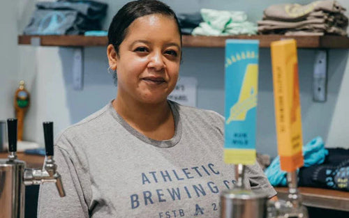 person smiling next to NA beer taps